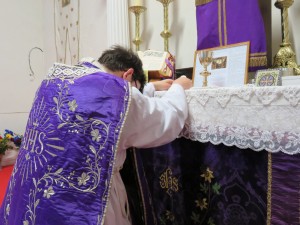 Le prêtre consacre le pain Eucharistique