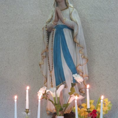 Aujourd'hui plus encore que les autres jours, la statue de la Vierge est entourée de mille soins
